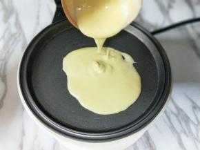 盛一勺面糊，倒入预热的华夫饼机器烤盘中。