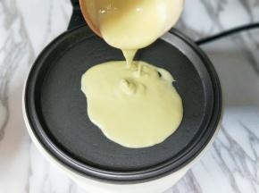 盛一勺面糊，倒入预热的华夫饼机器烤盘中。