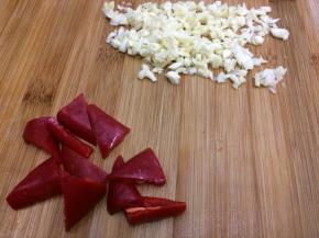 做法：将荷兰豆去掉两头和筋，然后用水洗干净，大蒜切成小粒，红椒切成块