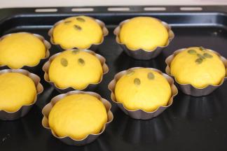 烤箱175度预热。二次发酵至模具的八分满即可，表面喷水撒南瓜仁