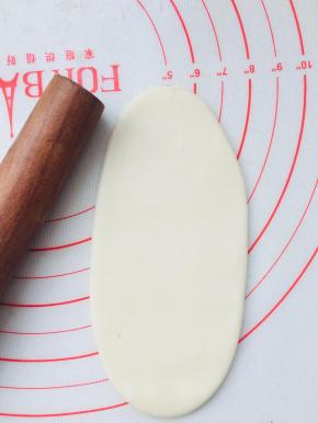 取一个松弛好的面团，按扁擀成牛舌型，要从中间往两头擀，不要回来擀。力度不大太大。也无需擀的太长。10厘米左右即可。