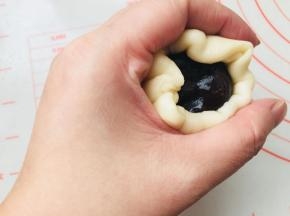 将馅料放到面皮中间位置，同样是利用虎口，边推边收口。