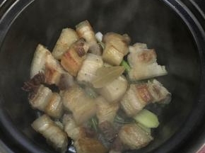 将煎好的五花肉放入砂锅中，加入香叶，八角，冰糖。