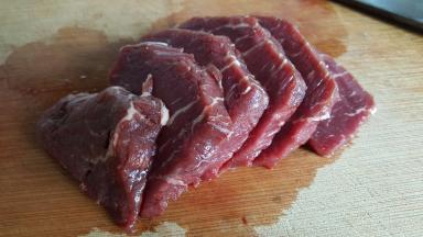 准备牛里脊肉250克，去掉筋膜后纵向切成厚一点的片。