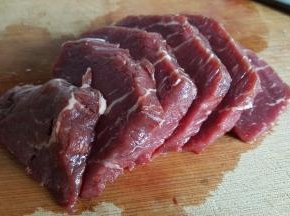 准备牛里脊肉250克，去掉筋膜后纵向切成厚一点的片。
