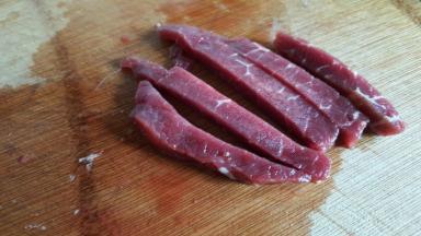 再将牛肉片切成稍宽一点的条状，我这次切的有点粗，建议不要切的太粗了，成品会比较粗壮。