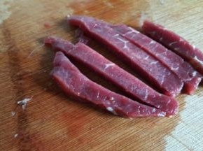再将牛肉片切成稍宽一点的条状，我这次切的有点粗，建议不要切的太粗了，成品会比较粗壮。
