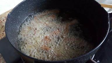 逐条放入裹好面糊的牛里脊肉进行煎炸。