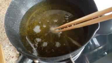 小的奶锅中放入足够多的植物油，中火加热至有面糊的筷子放入可以迅速的冒起泡泡。