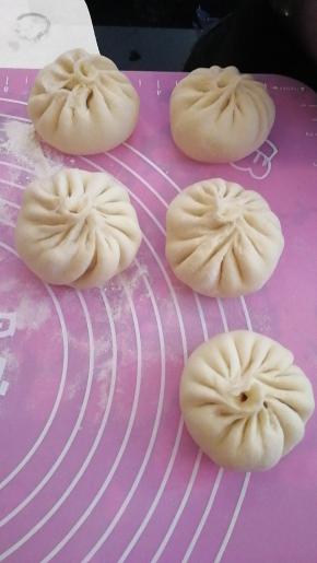 装入馅料，用大拇指捏着，食指将皮子一点一点压上来，