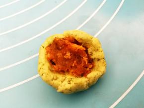 取一份小面团压扁，挖一点馅料