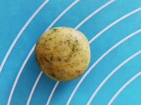 把馅料包裹起来，收口处捏紧，搓圆后稍压扁