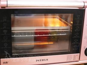 取出发酵好的面团，面团上再压一个不沾平底烤盘，送入预热好的烤箱，中层，上下火180℃，烘烤18分钟。