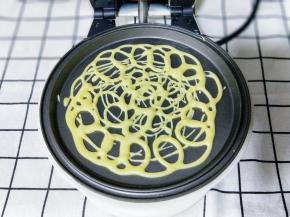 将面糊不规则的画圈挤在华夫饼机器的烤盘上约1分钟面糊凝固即可，#注意蕾丝蛋卷的密度要适度，太稀疏会断开，太密也会影响成品的美观及口感。#