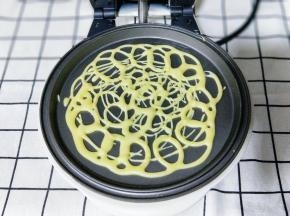 将面糊不规则的画圈挤在华夫饼机器的烤盘上约1分钟面糊凝固即可，#注意蕾丝蛋卷的密度要适度，太稀疏会断开，太密也会影响成品的美观及口感。#