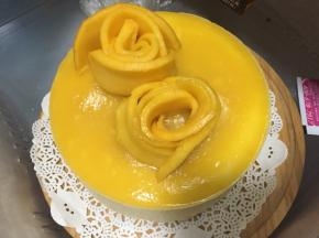 最后将芒果切片摆成玫瑰花状于慕斯蛋糕表面，放入冰箱冷藏半小时即可