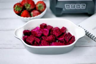 接着将红心火龙果切小块，将草莓去蒂切小块。