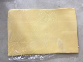 之后将保鲜袋对折，用擀面杖将黄油擀成均匀厚度的片，入冰箱冷冻