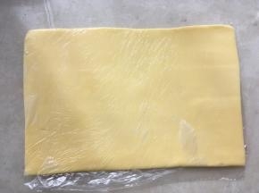 之后将保鲜袋对折，用擀面杖将黄油擀成均匀厚度的片，入冰箱冷冻