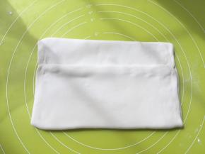 之后对折两侧的面片，将黄油包裹上，捏紧收口