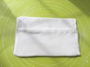 之后对折两侧的面片，将黄油包裹上，捏紧收口