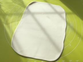 松弛好的面团擀成比保鲜袋大一点的长方形