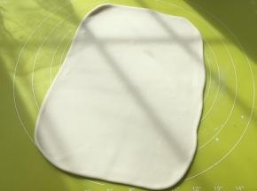 松弛好的面团擀成比保鲜袋大一点的长方形