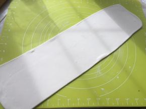 撒点干粉，将面片擀成长方形，长度跟揉面垫的长度相近