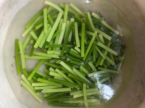 锅里放一锅水，加少量油煮开，洗净的蒜苗段放入焯水1分钟左右，捞出立即放入凉水中降温，备用。