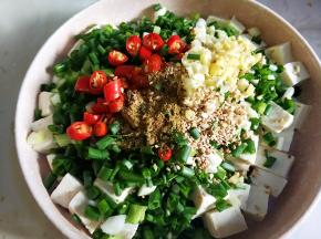 豆腐控干水，将葱姜蒜，小米椒，熟芝麻，花椒粉，五香粉放在豆腐上。