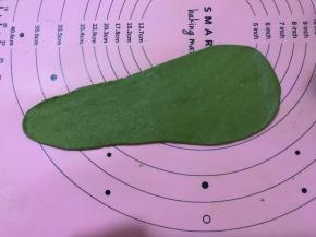 将醒好的面团，用擀面杖擀成牛舌状