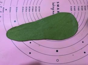 将醒好的面团，用擀面杖擀成牛舌状