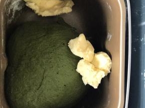 20分钟后揉成光滑面团时，加入黄油，继续揉面40分钟，至扩展状态