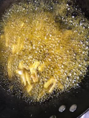 加入裹满淀粉的藕条，先中火炸一分钟，再大火炸至金黄色