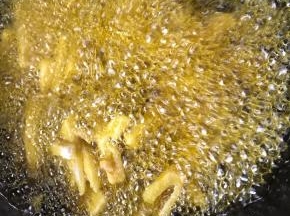 加入裹满淀粉的藕条，先中火炸一分钟，再大火炸至金黄色