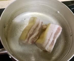 煮锅里加入清水加拍破的老姜烧水，水开了后放入三线肉