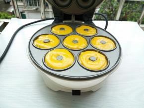 裱花袋剪一小口，一次把面糊挤入甜甜圈模具，盖上盖子，烤3-5分钟，烤至期间，可以打开观察一下成色，