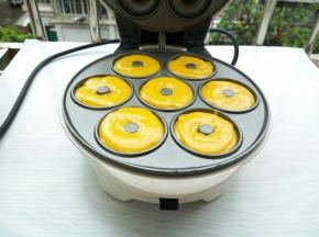 裱花袋剪一小口，一次把面糊挤入甜甜圈模具，盖上盖子，烤3-5分钟，烤至期间，可以打开观察一下成色，