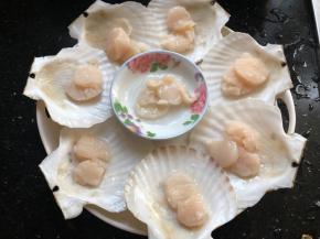 用刀把扇贝破开，沿着壳壁小心的把贝肉取下来，去掉内脏和腮，留下贝肉和月牙形的黄（我们家不喜欢吃黄被我扔掉了），放在贝壳上面。