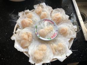 泡软的粉丝用剪刀剪断，垫在贝肉下面。