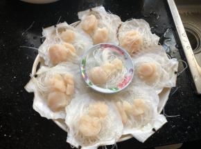 泡软的粉丝用剪刀剪断，垫在贝肉下面。