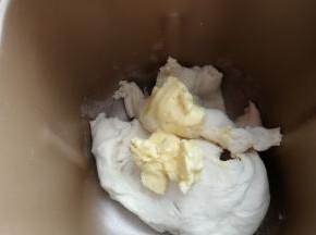 再加入室温软化的黄油继续揉面