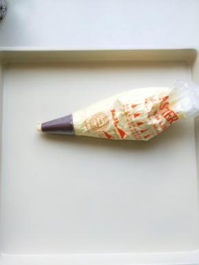 制成的面糊应是光滑可流淌的，取裱花袋撞上花嘴，倒入制好的面糊，