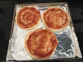 pizza饼底上抹上蕃茄酱
