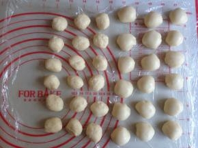 将静置过的油皮和油酥分成18份，每一份都搓圆