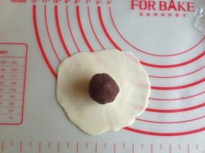 擀成中间厚，四周薄的圆形，放上馅料