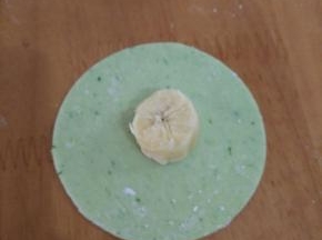 取一块饺子皮，放上一段香蕉。