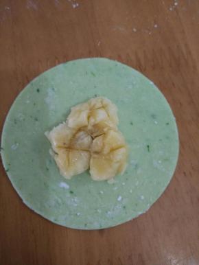用勺子把香蕉压扁，然后在饺子抹一圈水。