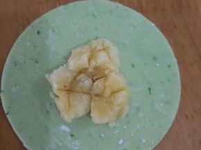 用勺子把香蕉压扁，然后在饺子抹一圈水。