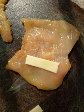 将腌好的鸡胸取出铺平，将芝士片放到鸡胸肉片的一边。(也可以多放点)